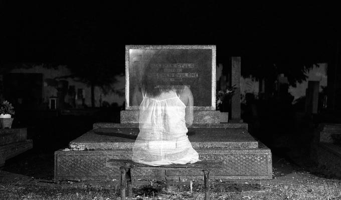 Niños fantasma: fantasma de niña frente a una tumba 