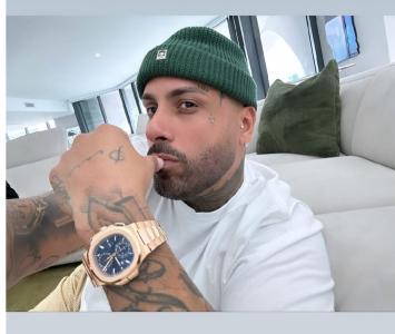 fotografía del rostro de Nicky Jam mostrando un reloj de lujo 