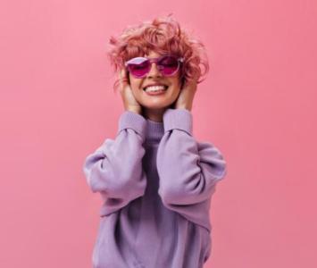 Modelo con cabello rosado y buzo de color lila digital. 