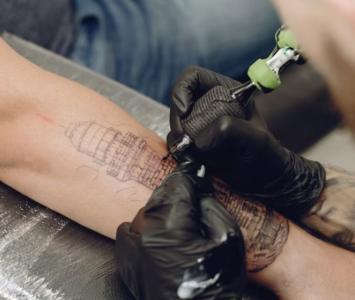 Persona tatuando un brazo: dónde duele más tatuarse