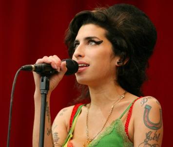 Amy Winehouse mirando hacia arriba mientras canta